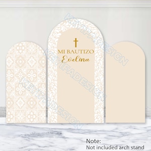 Pode incluir: Três capas arqueadas para fundo em bege e branco. O painel esquerdo apresenta um padrão de azulejos brancos. O painel central tem uma borda de folhas brancas, uma cruz dourada e o texto MI BAUTIZO Evelina. Painel direito bege liso.