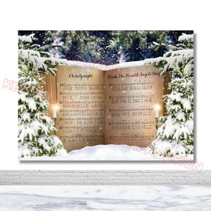 May include: A Christmas-themed print featuring open sheet music with the titles "Oh holy night" and "Hark The Herald Angels Sing." The background includes snow-covered pine trees and a snowy landscape. Two lit candles flank the sheet music.