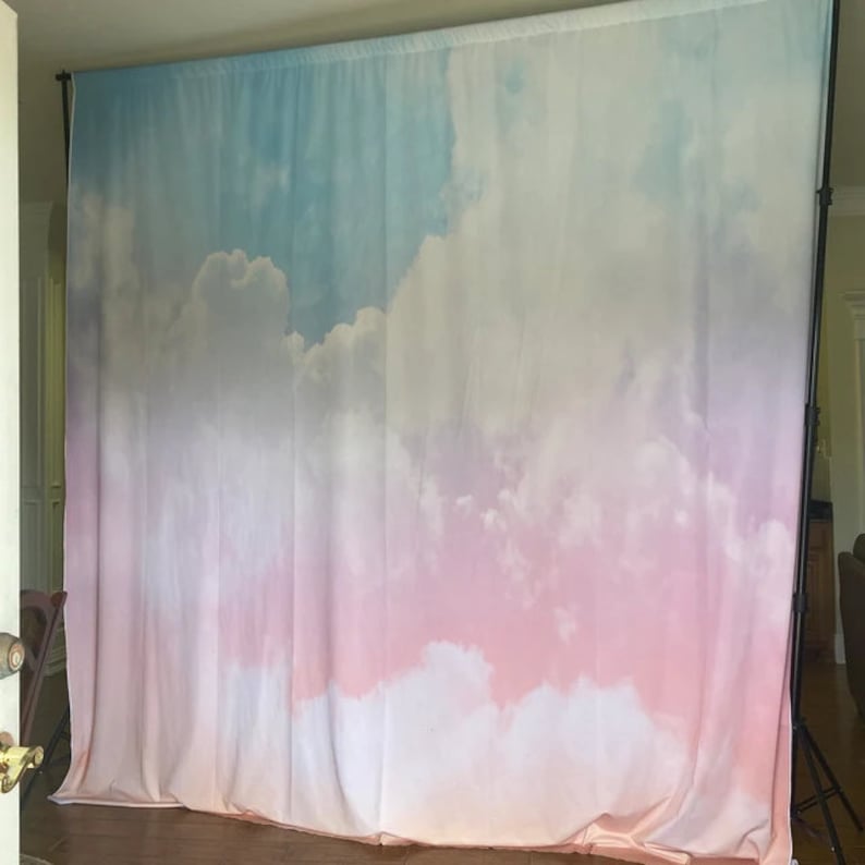 May include: A backdrop for photography featuring a gradient of blue, pink, and white with a cloud pattern.