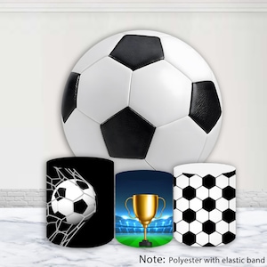 May include: Three black and white soccer-themed fabric covers for a round table. The covers feature a soccer ball in a net, a gold trophy on a green field, and a black and white soccer ball pattern.