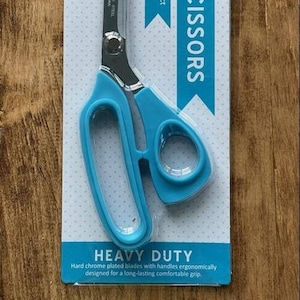 May include: 9.5" ribbon scissors with blue handles and stainless steel blades. The package reads "Heavy Duty" and "Professional grade tailoring shears perfect for cutting wired ribbon and more."