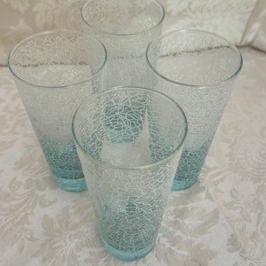 May include: Set of four clear glass tumblers with a white crackle design and a light blue tint.