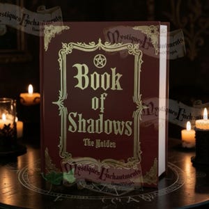 May include: A dark red hardback book titled Book of Shadows with gold lettering and a pentagram symbol on the front cover. The book is enclosed in an ornate gold frame design and features the text The Maiden printed below the main title.