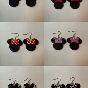May include: A collection of six pairs of dangle earrings featuring black mouse-shaped silhouettes. The designs include red bows, red glitter bows, red bows with white polka dots, pink glitter bows, and two variations of black and white animal print bows.