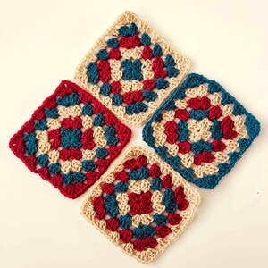 May include: Four crocheted granny squares in shades of cream, teal, and red. Each square features a central circle design.