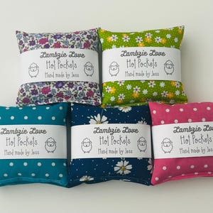 May include: Five square fabric pouches with various patterns including floral and polka dot designs. Each pouch features a white paper band printed with the text Lambzie Love Hot Pockets Hand made by Jess and a small sheep illustration on each side.