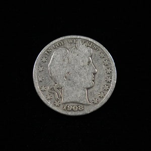 May include: A silver US half dollar coin with the words "In God We Trust" and the year "1908" inscribed on it. The coin features a profile of a woman's head.