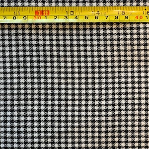 Pode incluir: Tecido xadrez branco e preto com uma fita métrica amarela no topo. A fita indica 1 pé, 30,1 polegadas, 13 polegadas, 14 polegadas, 15 polegadas, 16 polegadas.