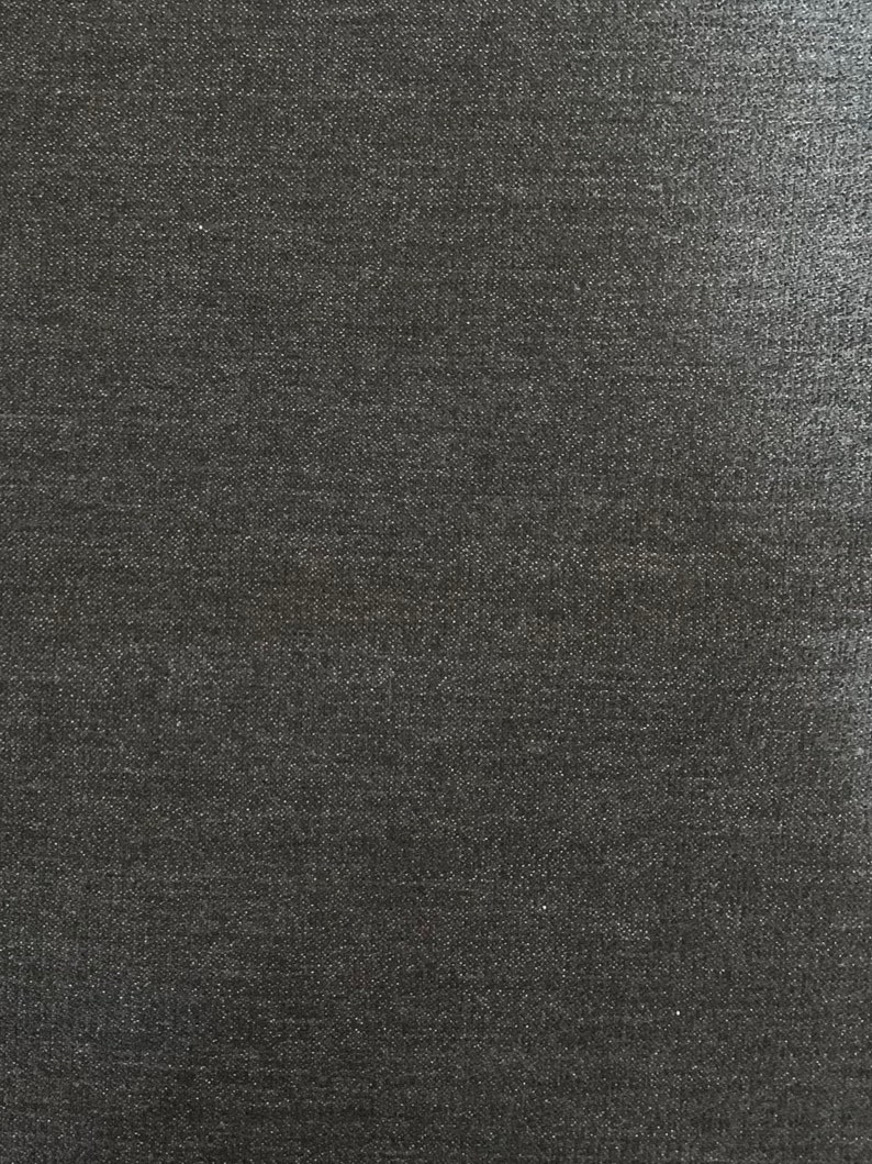 May include: A close-up of a dark gray textured fabric with a subtle sheen.