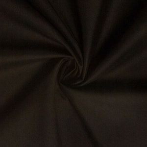 May include: A close-up of a dark brown fabric with a smooth texture. The fabric is folded and draped, showing its soft and pliable nature.