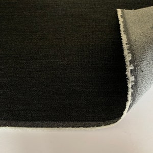 May include: Close-up of a dark gray fabric with a white edge. The fabric has a subtle texture and a slightly rough feel.
