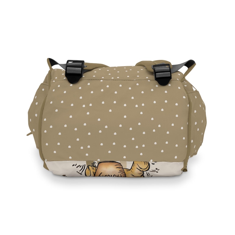 May include: A tan polka dot backpack with adjustable straps. The backpack has a cartoon illustration of a bear on the bottom.