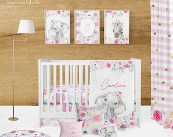 May include: A pink and white floral crib bedding set with a personalized elephant design. The set includes a blanket, a fitted sheet, a crib skirt, and a pillow. The blanket features the name "Caroline" in pink lettering. The elephant design is repeated on the pillow and the fitted sheet. The crib skirt is white with a pink floral border.