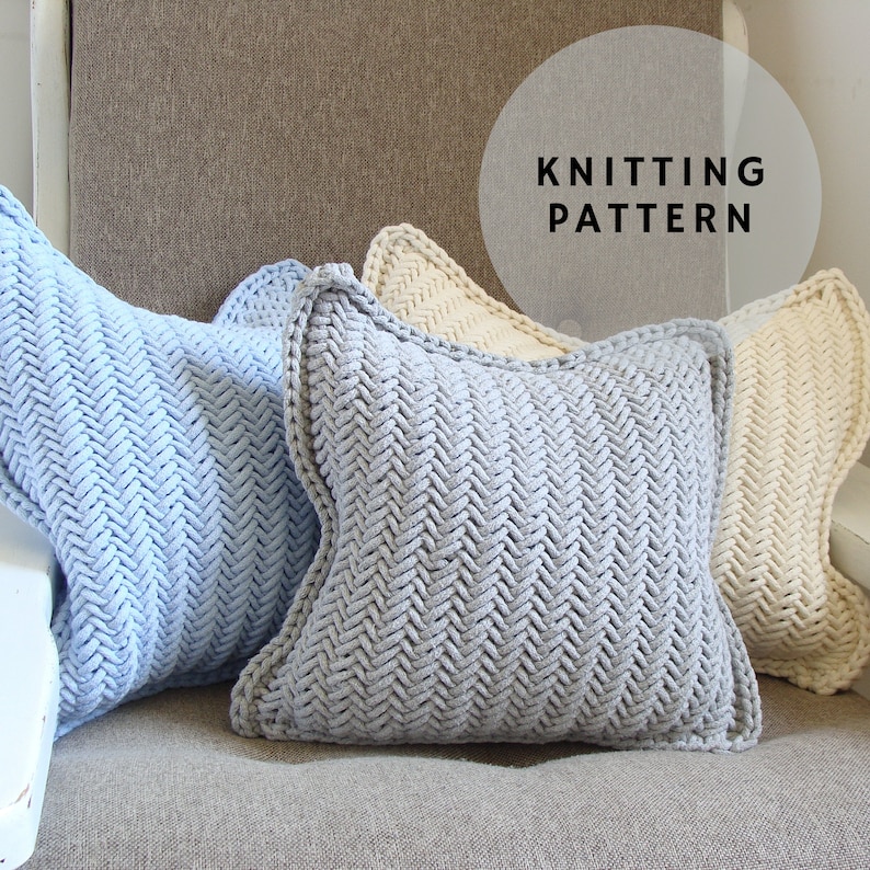 May include: Three knitted pillow covers in a chevron pattern. The pillows are light blue, gray, and cream.