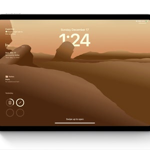 Peut inclure: Une tablette affichant un écran de verrouillage avec un fond d'écran représentant un paysage désertique brun. L'écran indique l'heure 1:24, la date du dimanche 17 décembre, la météo de Cupertino, des événements, des notes et des icônes circulaires.