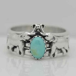 May include: A silver ring with two elephants on either side of a turquoise stone.