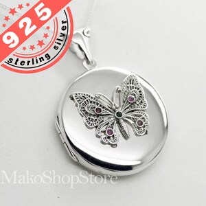Peut inclure: Un collier avec un médaillon en argent en forme de papillon. Le papillon est orné de pierres précieuses roses et vertes. Le médaillon est gravé avec "925 sterling silver".
