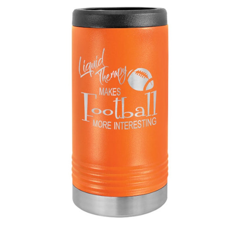 May include: Orange stainless steel can cooler with a silver lid and bottom. It has a white graphic that says "Liquid Therapy Makes Football More Interesting" with a football graphic.