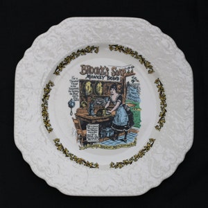 May include: A white ceramic plate with a gold border and a colorful illustration of a woman in a kitchen. The illustration is for Brooke's Soap, Monkey Brand, and the text says "Makes Bright Reflections".