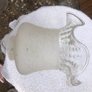 Könnte beinhalten: Ein weißer Lampenschirm aus Glas mit einem gekräuselten Rand und einem Perlmuster. Der Lampenschirm ist aus mattem Glas und hat ein zartes, vintage-mäßiges Aussehen.