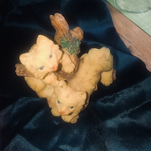 Two cats playing on a tree stump figurine