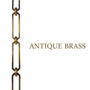 May include: A vertical antique brass chain featuring elongated rectangular links connected by smaller circular rings. The text "ANTIQUE BRASS" is printed in a matching metallic gold-toned font to the right of the metal chain links.