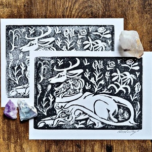 Può includere: Stampa a linoleum in bianco e nero di un cervo stilizzato su sfondo floreale. Il cervo è raffigurato in una posa reclinata con la testa girata di lato. La stampa è firmata "Elsie Woolley" in basso a destra.