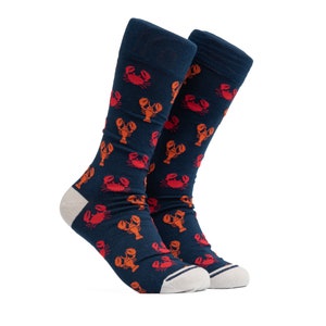 May include: A pair of blue socks with a pattern of orange and red lobsters. The socks are folded and displayed on a white background.