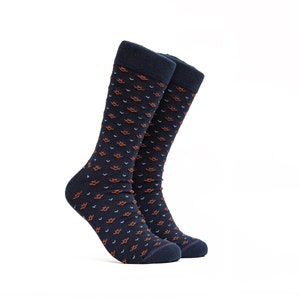 May include: A pair of navy blue socks with a repeating pattern of small orange and blue shapes.