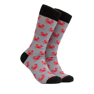 May include: A pair of gray socks with a red crab pattern. The socks have black cuffs.