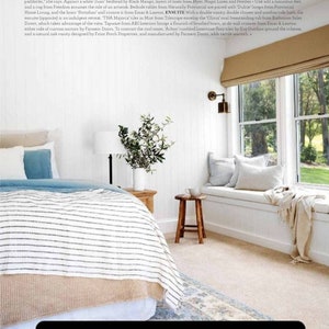 K&ouml;nnte beinhalten: Ein wei&szlig;es Schlafzimmer mit einer gro&szlig;en Fensterbank, einem Bett mit einer gestreiften Bettdecke und einem Holzhocker. Die Fensterbank ist mit einem elfenbeinfarbenen Stoff bezogen und hat eine Wolldecke. Der Text "Our cushions had been featured in Home Beautiful Magazine March 2022" befindet sich am unteren Rand des Bildes.