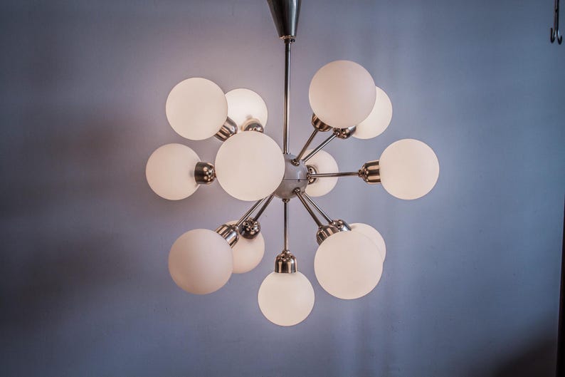 May include: A modern, chrome and white glass chandelier with multiple globe-shaped lights.