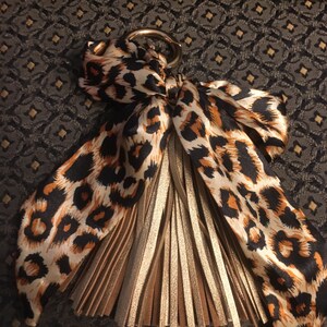 Dije de borla con lazo trenzado para bufanda de bolso, herraje con clip de anillo en O dorado en el asa del bolso, colores marrón cálido y negro con estampado de leopardo, gran accesorio