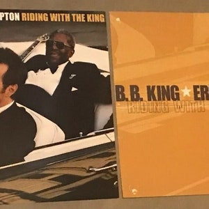 May include: A black and white photograph of B.B. King and Eric Clapton on the cover of their album "Riding with the King".