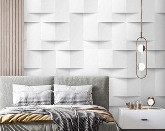 May include: A modern bedroom with a gray upholstered bed with a white and black patterned throw blanket. The bedroom has a white wall with a 3D geometric pattern, two white nightstands, and two gold pendant lights.