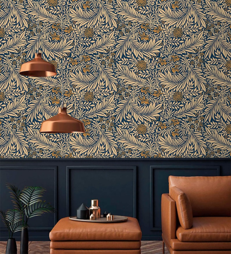 May include: A living room interior with a dark blue wall covered in a beige and gold floral wallpaper. The room features a brown leather armchair, a coffee table with a brown leather top, and two copper pendant lights.