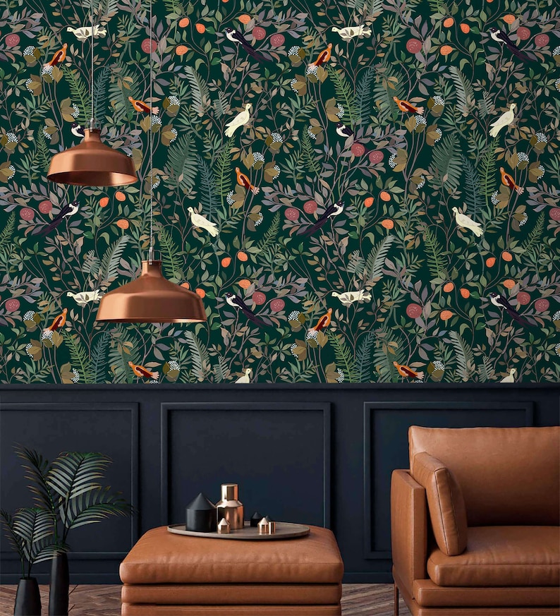 K&ouml;nnte beinhalten: Eine dunkelgr&uuml;ne Tapete mit einem sich wiederholenden Muster aus V&ouml;geln, Bl&auml;ttern und Blumen. Die Tapete ist in einem Raum mit einem braunen Ledersofa und einem Couchtisch zu sehen.