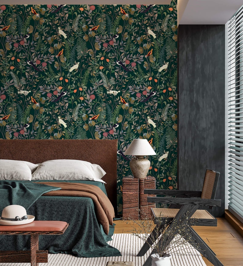 K&ouml;nnte beinhalten: Ein Schlafzimmer mit einer dunkelgr&uuml;nen Tapete mit einem sich wiederholenden Muster aus V&ouml;geln, Bl&auml;ttern und Blumen. Die Tapete befindet sich an einer Wand des Raumes, der auch ein Bett mit braunen Bettw&auml;sche, eine braune Holzbank und einen schwarzen Stuhl hat. Neben dem Bett steht eine Lampe auf einem Holztisch.