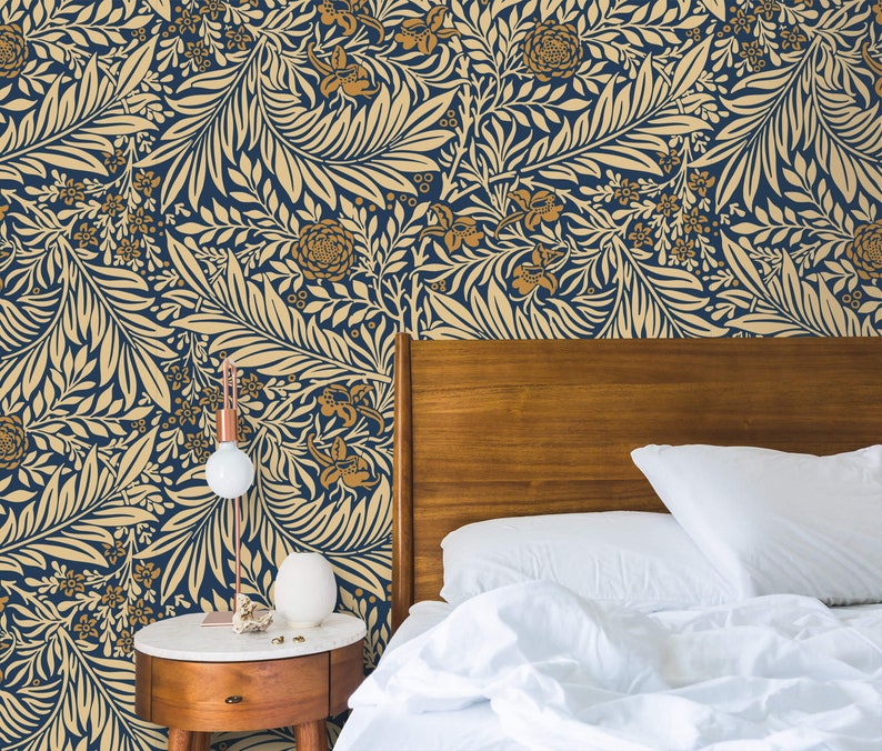 May include: A white bed with a wooden headboard and white bedding. The wall behind the bed is covered in a blue and gold floral wallpaper.