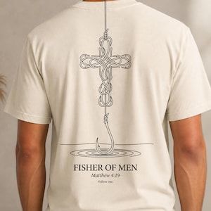 Peut inclure: Un t-shirt à manches courtes de couleur crème avec un motif graphique en lignes noires au dos. Le dessin représente une croix formée par des hameçons entrelacés, avec un hameçon suspendu en dessous. Le texte indique : FISHER OF MEN, Matthew 4:19, Follow me.
