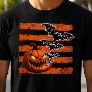 Peut inclure: Un t-shirt noir à manches courtes avec une impression graphique représentant une citrouille orange sculptée aux yeux jaunes brillants et à la bouche dentelée, accompagnée d'une volée de chauves-souris noires sur des rayures orange usées.