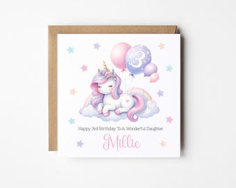 May include: A white unicorn with a pink mane and tail is lying on a cloud with a rainbow. The unicorn has a flower crown on its head. There are pink, purple, and blue balloons with stars and the number 3 on them. The card says "Happy 3rd Birthday to a Wonderful Daughter Millie".
