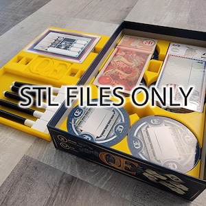 Puede incluir: Una caja de juego de mesa amarilla y azul con una tapa negra. La caja está abierta y muestra los componentes del juego, incluyendo un tablero de juego, cartas y fichas. El texto "STL FILES ONLY" está impreso en la caja.