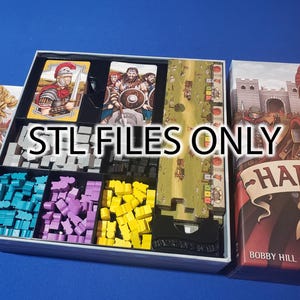May include: A board game box with a grey lid and a colourful box insert. The box insert has compartments for storing game pieces. The box has a label that says "Hadrian's Wall".