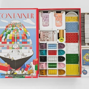 May include: The board game Container features a box lid with a large cargo ship illustration and the text CONTAINER. Inside, organized compartments hold paper currency marked $20 and $10, small plastic ships, and stacks of colored cubes.