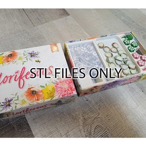 May include: A floral-themed board game box with the title "Floriferous" and the text "Florifest" on the front. The box is open to reveal a game board with a floral design and a tray of colorful game pieces.