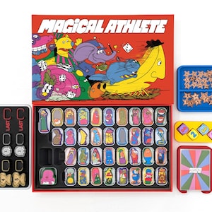 May include: A board game titled "Magical Athlete" with a red box featuring cartoon characters. The game includes character cards, dice, star-shaped tokens, and number tiles. The game is designed with bright colors and a playful aesthetic.