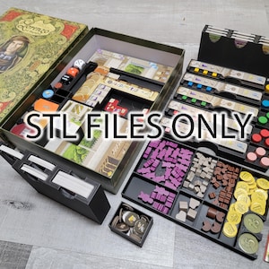 以下が含まれることがあります： ゲームの駒やカードを収納するための仕切り付きの黒い収納ボックス。ボックスには「STL FILES ONLY」とラベルが貼られています。