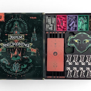 May include: An open board game box titled "Realm Reckoning". The box contains various game pieces in red, purple, and green. The box is black with a dark green and black design. The game pieces are stored in separate compartments.