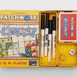 May include: The Patchwork Doodle board game box features a yellow cover with the title and a quilt-patterned illustration. Inside, the yellow tray contains four black dry-erase markers, a deck of cards, a yellow wooden token, and a white die.